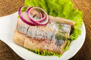 Herring fillet in a bowl on wooden background photo