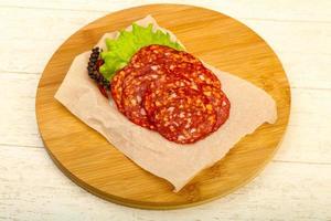 Chorizo sausage on wooden board and wooden background photo