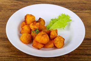 Baked potato on the plate and wooden background photo