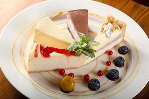 Cheesecake assortment on the plate and wooden background photo