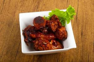 Chicken wings in a bowl on wooden background photo