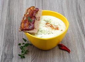 Cheese soup in a bowl on wooden background photo