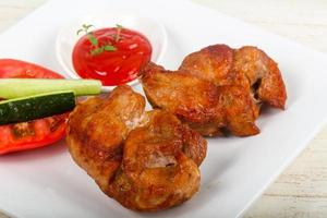 Pork BBQ on the plate and wooden background photo