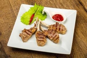 Grilled lamb on the plate and wooden background photo