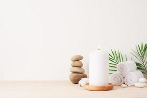 Spa treatment with candles, towel and stones on white background. Close up, copy space. photo