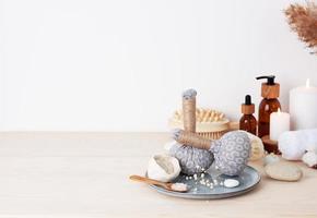 Spa treatment with natural skin care products, towel and herbal bag on white background. Close up, copy space. photo