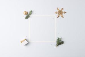 Christmas decorations with white frame and gift on white background. Flat lay, copy space photo