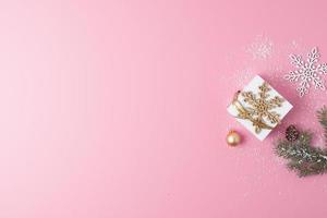 Christmas decorations with gift on pink background. Flat lay, copy space photo