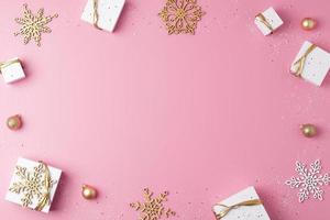 Christmas decorations with packaging gifts and balls on pink background. Flat lay, copy space photo