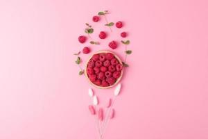 Creative summer background made from fresh berries and flowers on pink. Flat lay, copy space. photo