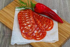 Chorizo on wooden board and wooden background photo