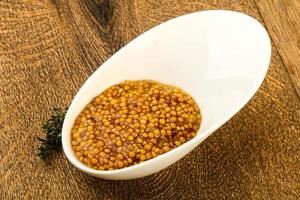 Dijon mustard in a bowl on wooden background photo