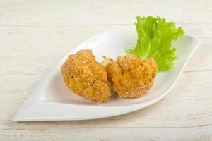 Crispy cauliflower in a bowl on wooden background photo