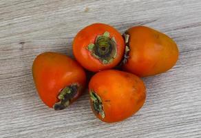 Persimmon on wood photo