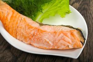 Steamed salmon on the plate and wooden background photo