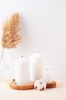 Home decoration with candles and flowers over white wall. Interior design concept. Close up, copy space