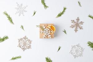 Christmas background with packaging gift in craft paper and rosemary on white. Flat lay, copy space photo