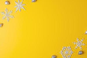 fondo mínimo amarillo navideño con copos de nieve. endecha plana, espacio de copia foto