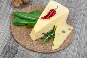 Yellow cheese on wooden board and wooden background photo