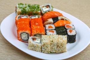 Sushi set on the plate and wooden background photo