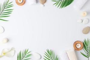 Spa treatment with towel, candles and palm on white background. Flat lay, copy space photo