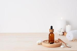 Spa treatment with cosmetic bottle, candles and towel on white background. Close up, copy space. photo