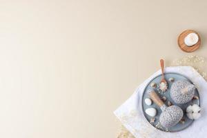 Spa treatment with towel, candles and herbal bag on beige background. Flat lay, copy space. photo