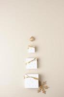 Christmas decorations with packaging gifts and balls on pastel beige background. Flat lay, copy space photo
