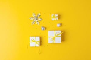 Minimal composition with Christmas decoration and balls on yellow background. Flat lay, copy space photo
