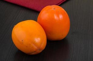 Persimmon on wood photo