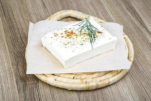 Feta cheese on wooden board and wooden background photo