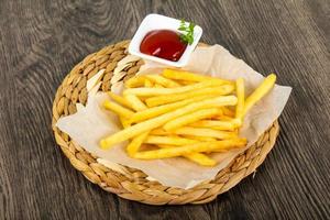French fries on wooden board and wooden background photo