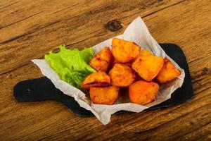 Baked potato on wooden board and wooden background photo