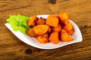 Baked potato in a bowl on wooden background photo