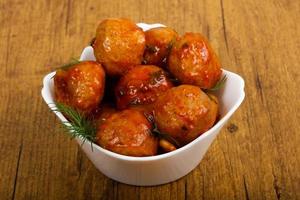 Meat balls in a bowl on wooden background photo