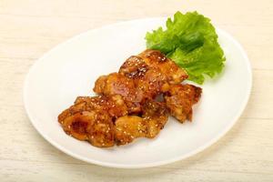 Teriyaki thighs on the plate and wooden background photo