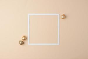 Christmas beige minimal background with white frame and beige ball. Flat lay, copy space photo