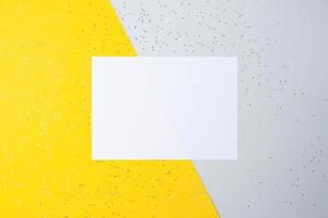 Christmas yellow and grey minimal background with mock up greetings card and confetti. Flat lay, copy space photo