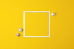 Christmas yellow minimal background with white frame and grey ball. Flat lay, copy space photo