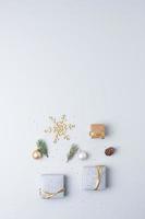 Christmas decorations with packaging gifts and Christmas tree on grey background. Flat lay, copy space photo