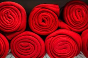 Rolls of many red plaids on the shelf photo
