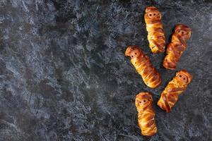 Scary sausage mummies in dough for kids party. Funny crazy Halloween food for children. photo