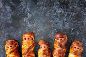 Scary sausage mummies in dough for kids party. Funny crazy Halloween food for children. photo