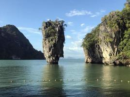 Thailand, an island in the ocean. In the photo is the ocean, in the middle of the photo is a rock in the water.