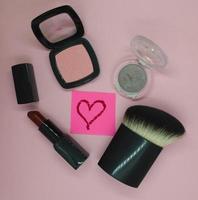 Cosmetic brush, blush, red lipstick, eye shadow photo