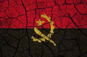 Dry soil pattern on the flag of Angola. Country with drought concept. Water problem. Dry cracked earth country. photo