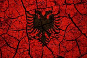 Dry soil pattern on the flag of Albania. Country with drought concept. Water problem. Dry cracked earth country. photo