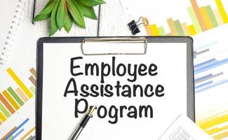 On a light background - light blue diagrams, paper clips and a sheet of paper with the text EAP Employee Assistance Program. photo