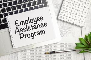 EAP Employee Assistance Program. text and notepad with pen, charts and calculator photo