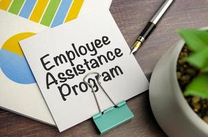 On a light background - light blue diagrams, paper clips and a sheet of paper with the text EAP Employee Assistance Program. photo